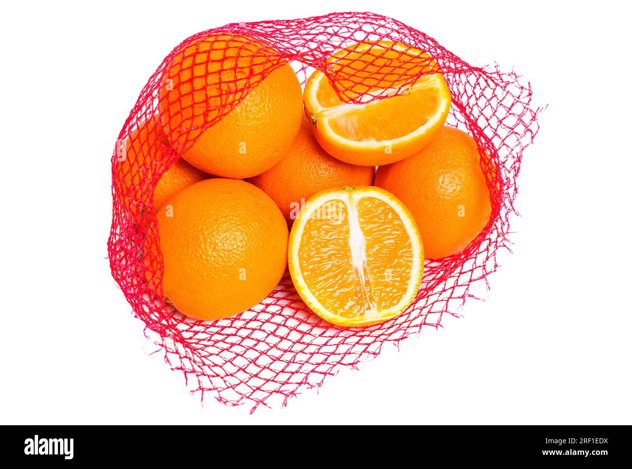 Arance fresche e succose in un sacchetto rosso a rete isolato su sfondo bianco. Un'arancia viene tagliata a metà. Foto Stock