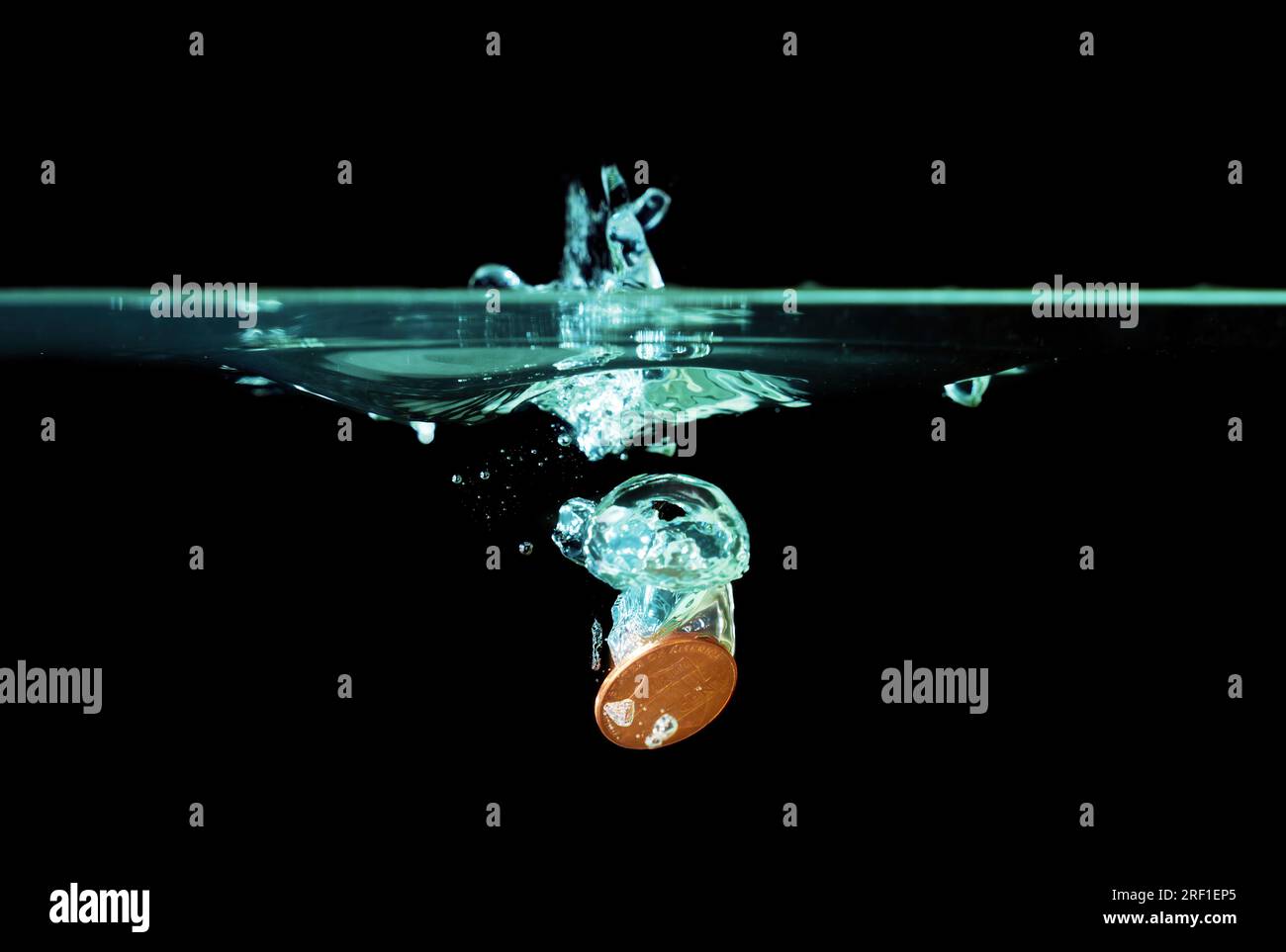 Penny è caduta in acqua con spruzzi sul nero. Concetto correlato al flusso di cassa e al Money in Motion. Foto Stock