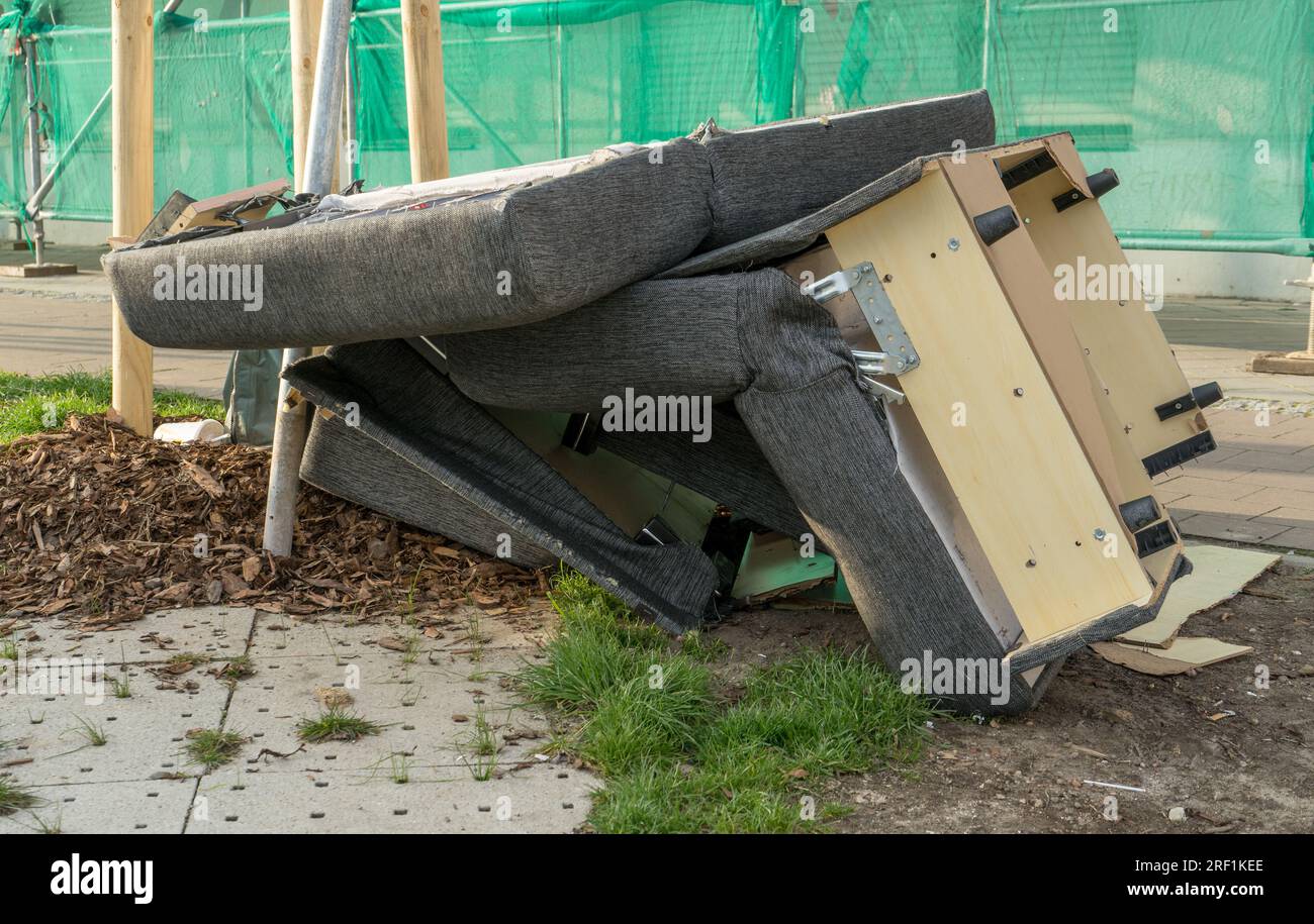 Un mucchio di rifiuti ingombrante con vecchi mobili imbottiti sul lato della strada Foto Stock