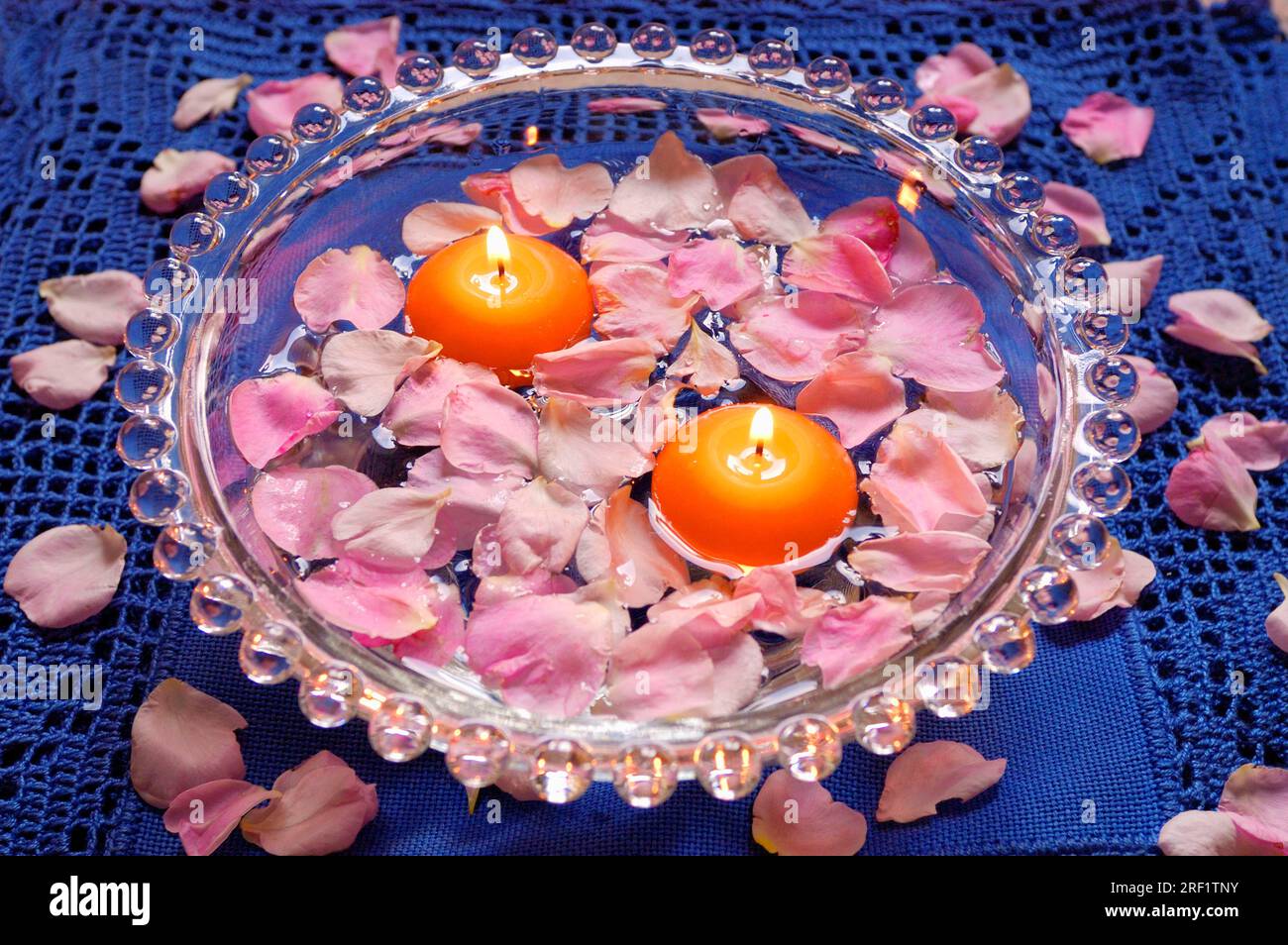 Candele e petali di rosa in un recipiente con acqua Foto stock - Alamy