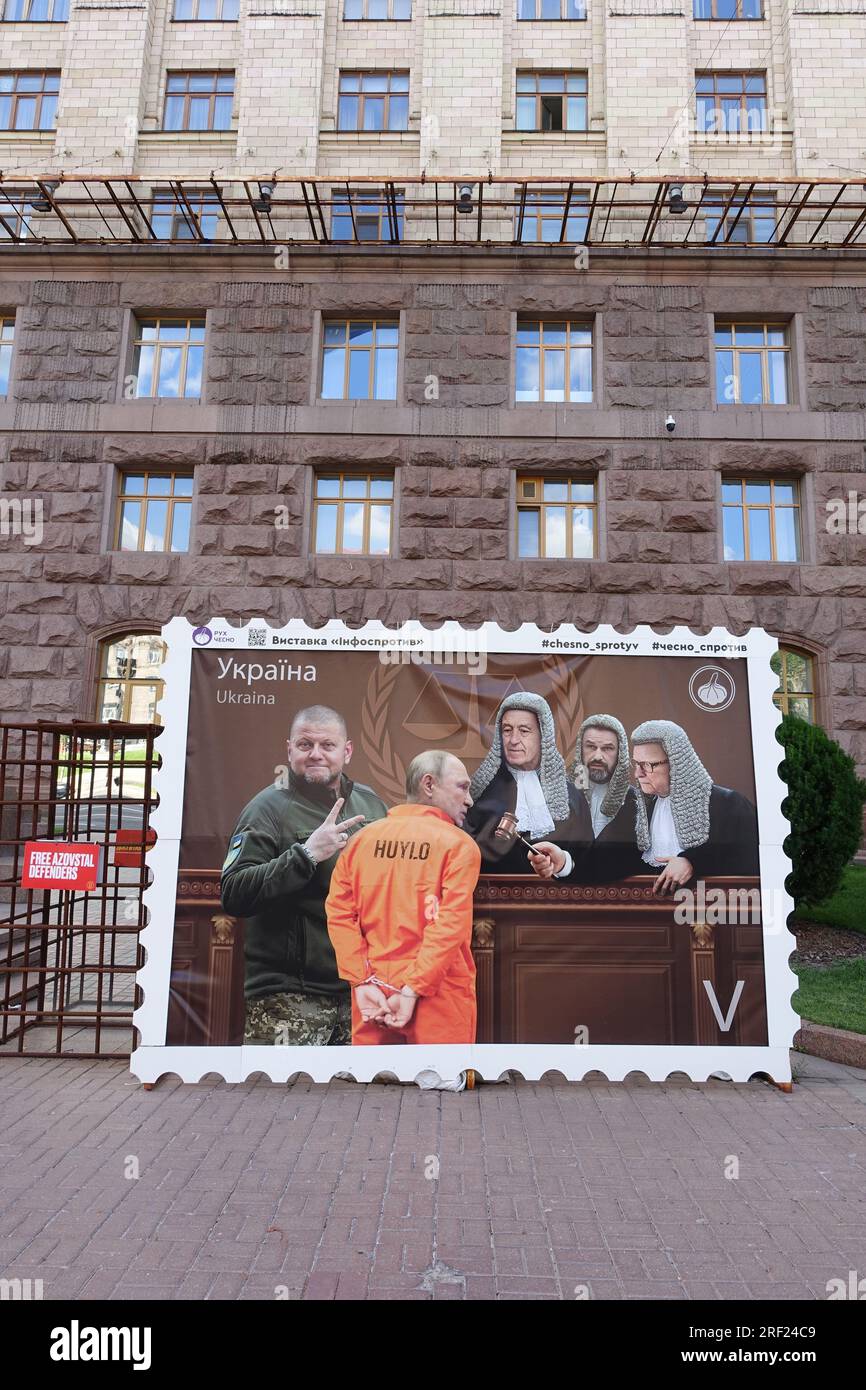 Nelle strade di Kiev, un francobollo gigante raffigura il processo di Putin dinanzi al Tribunale penale internazionale. È guidato dai giudici da Zaluzhnyi Foto Stock