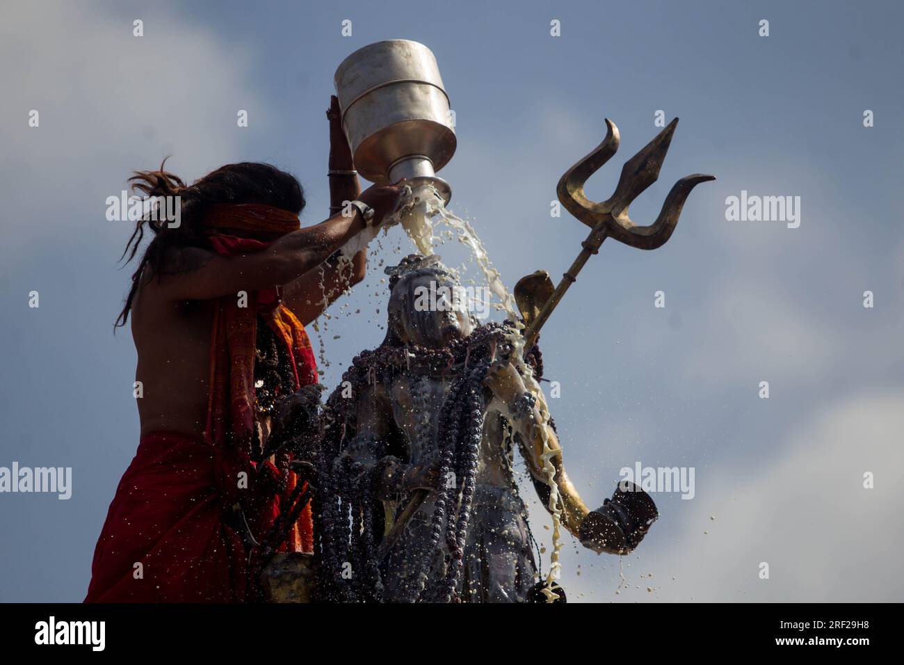 Kathmandu, Nepal. 31 luglio 2023. Un sacerdote indù bagna un idolo del Signore Shiva con Panchamrit, un'offerta tradizionale fatta di latte, cagliate, miele, ghee e zucchero, in un rituale durante il mese sacro indù di Shrawan a Kathmandu, Nepal, il 31 luglio 2023. Gli indù considerano Shrawan come un momento di buon auspicio per pregare il Signore Shiva per la felicità e la prosperità. Crediti: Sulav Shrestha/Xinhua/Alamy Live News Foto Stock
