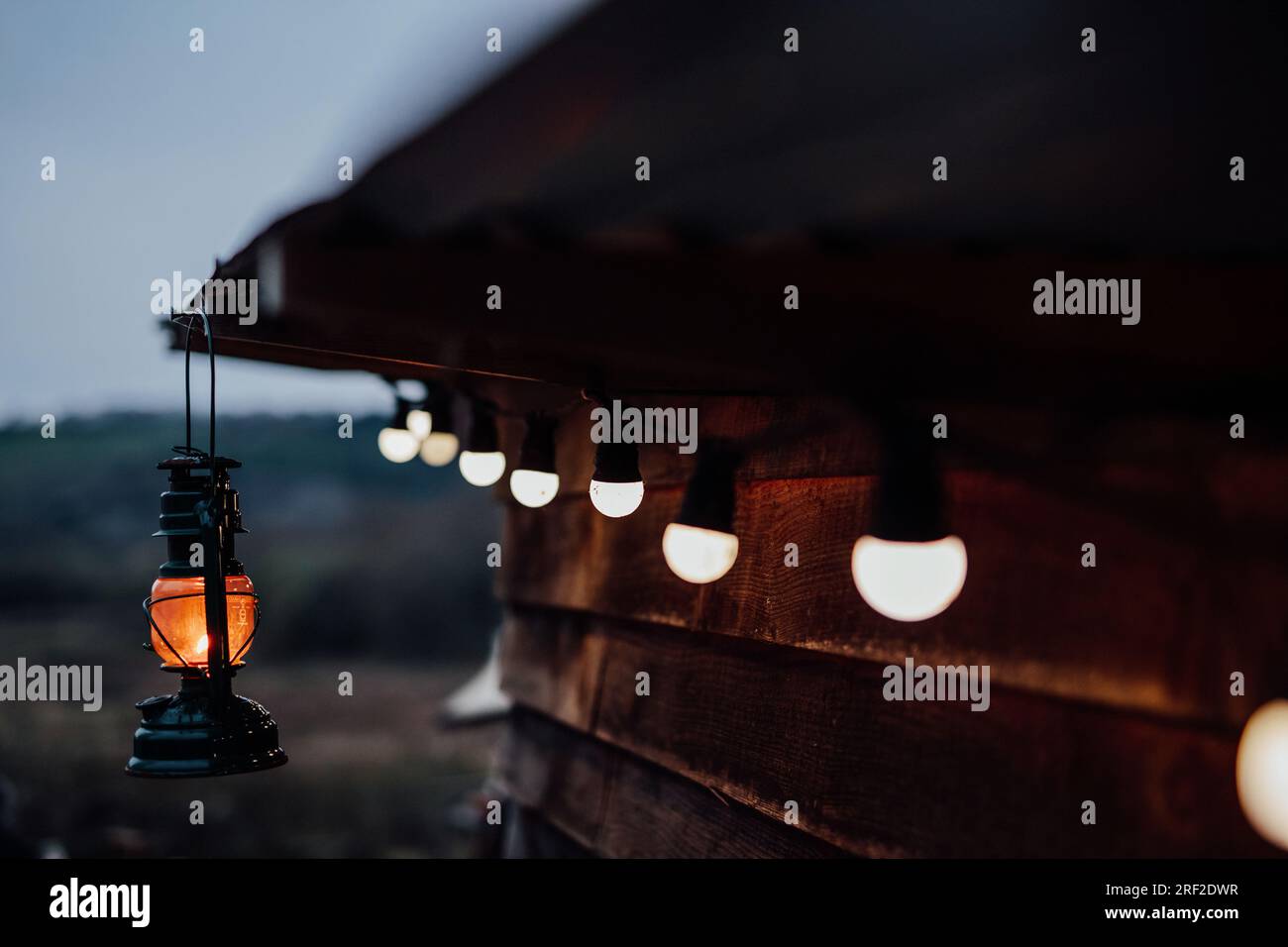 Lanterna tempesta e illuminazione festoon da un'accogliente cabina in legno, Galles Foto Stock