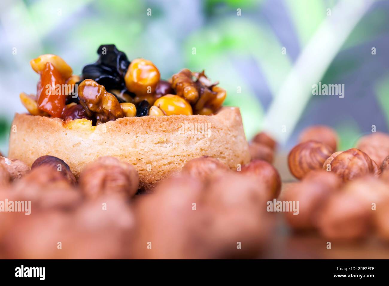 crostata di grano con ripieno dolce, croccante croccante con nocciole, arachidi e altri ingredienti, crostata di pasta di grano con noci e frutta secca in crea Foto Stock