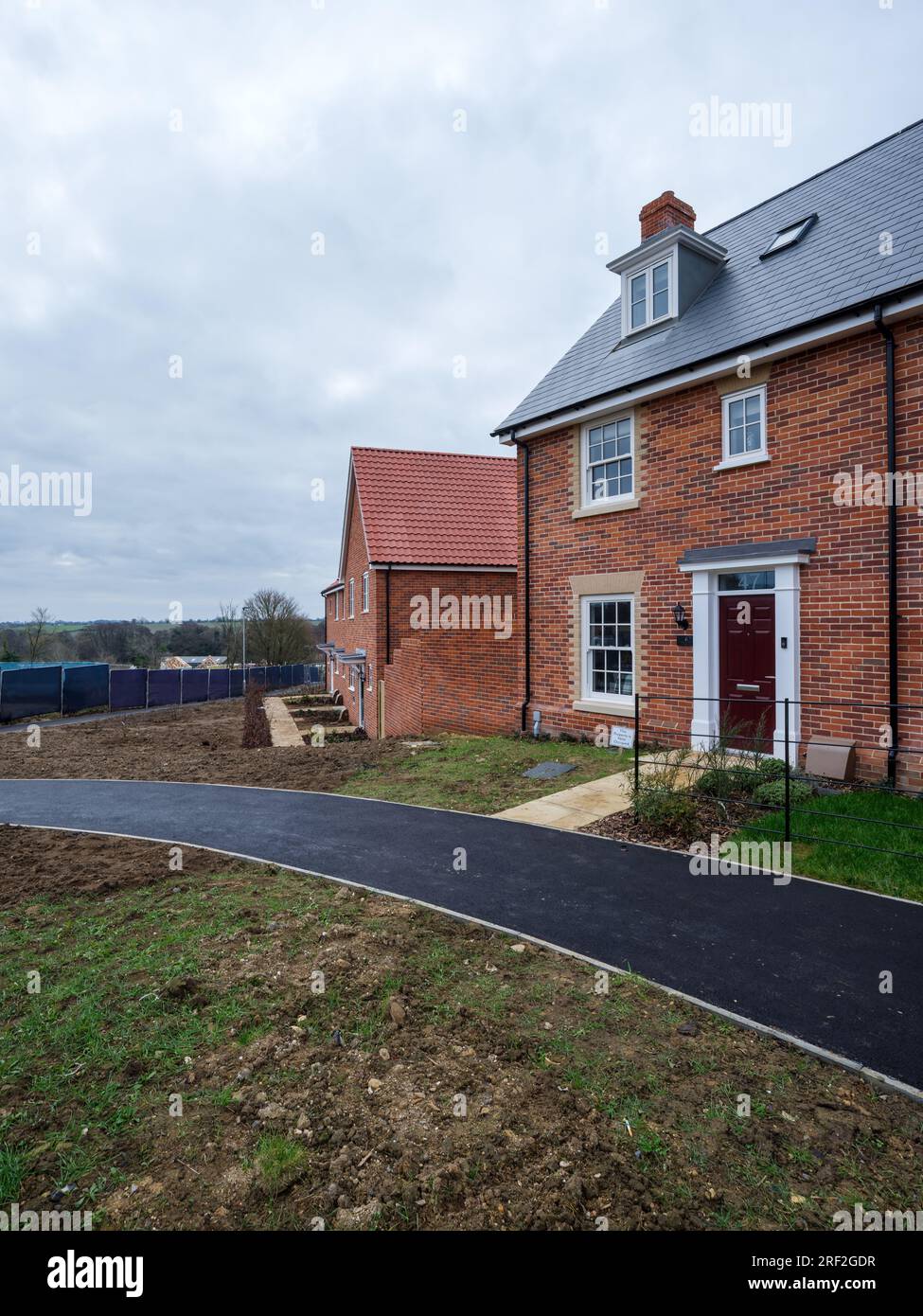 Nuovissimo edificio moderno a tre piani costruito in mattoni costruito in stile tradizionale sullo sviluppo abitativo a Suffolk, Inghilterra. Foto Stock