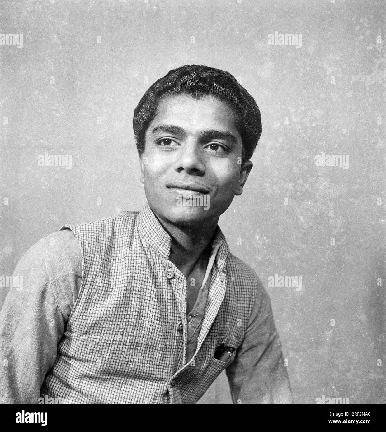Vecchia foto vintage in bianco e nero degli anni '1900 di un ritratto da studio di un uomo indiano che indossa una giacca India anni '1940 Foto Stock
