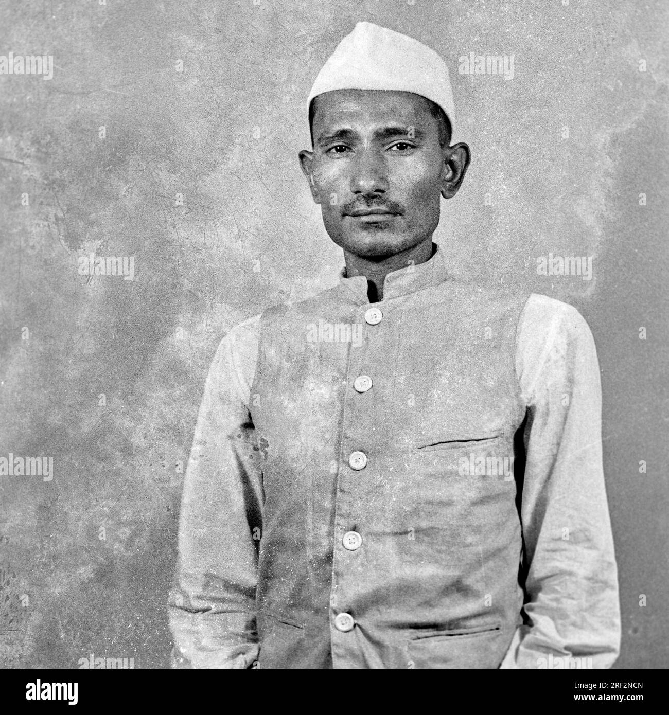 Vecchio ritratto in bianco e nero anni '1900 dell'uomo indiano che indossa una giacca bianca topi cap India 1940 Foto Stock