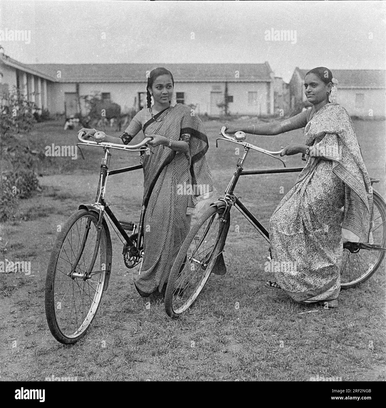 Vecchia immagine vintage in bianco e nero degli anni '1900 di donne indiane, ragazze, biciclette che indossano sari India 1940 Foto Stock