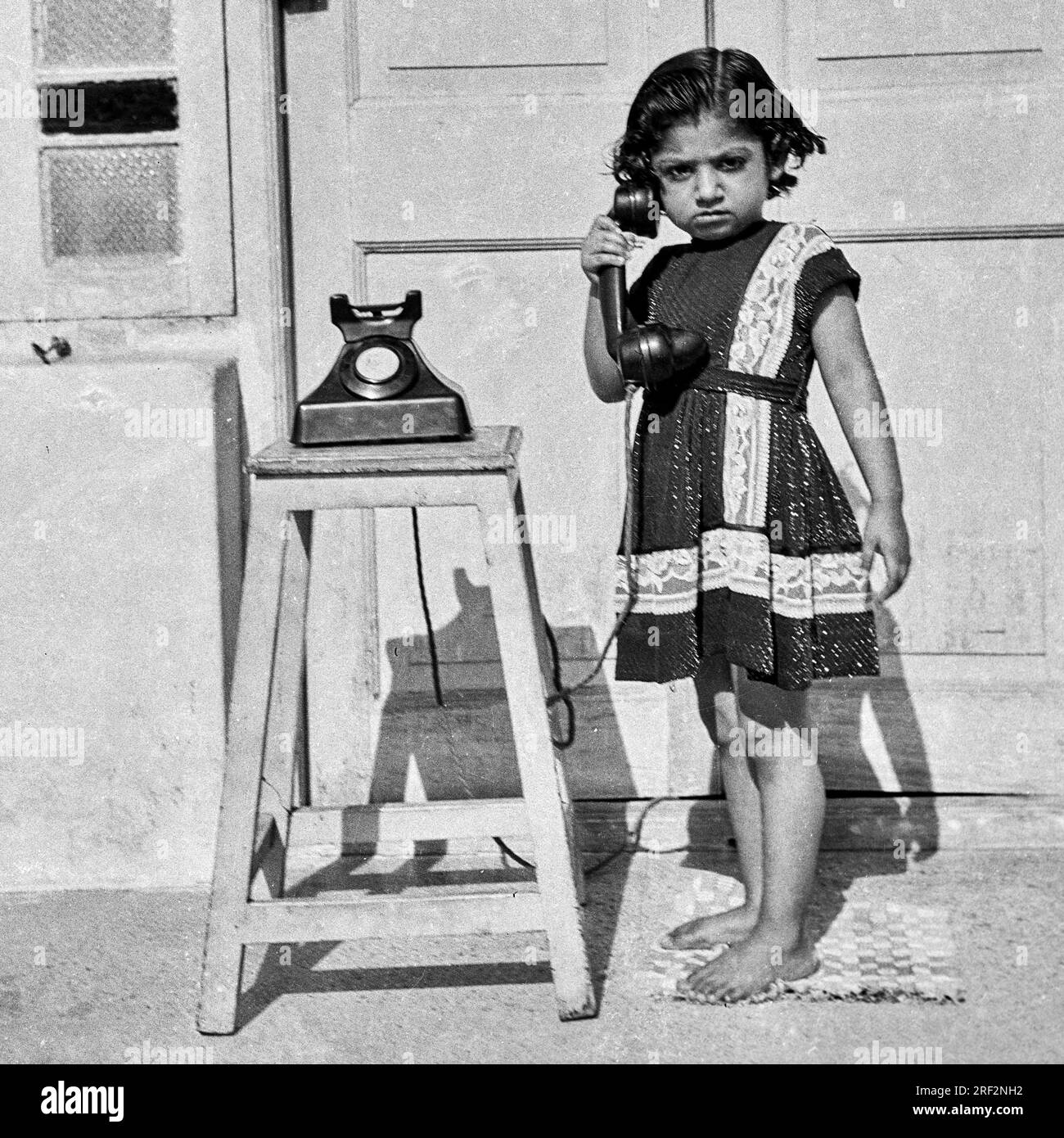 Vecchia immagine vintage anni '1900 in bianco e nero di una ragazza indiana, prima nera, nessun telefono senza quadrante, India 1940s Foto Stock Vecchia immagine vintage anni '1900 in bianco e nero di una ragazza indiana, prima nera, nessun telefono senza quadrante, India 1940s Foto Stock