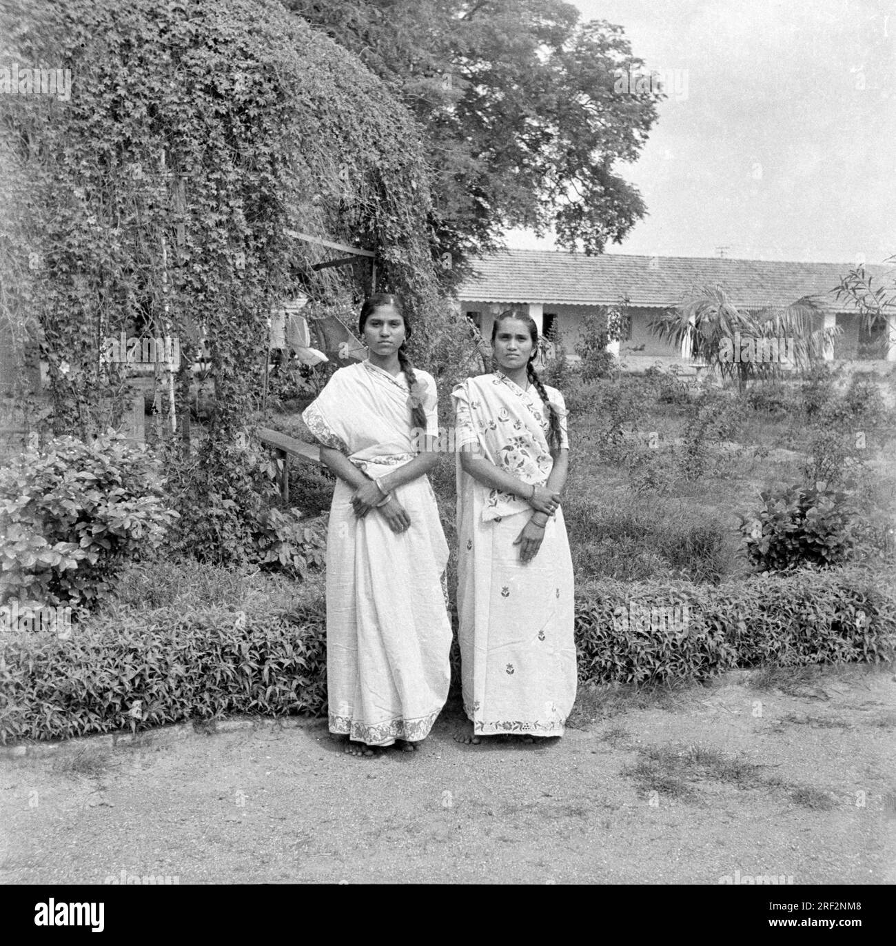 Vecchia foto vintage in bianco e nero degli anni '1900 di gemelle indiane ritratto con giardino saris India 1940s Foto Stock