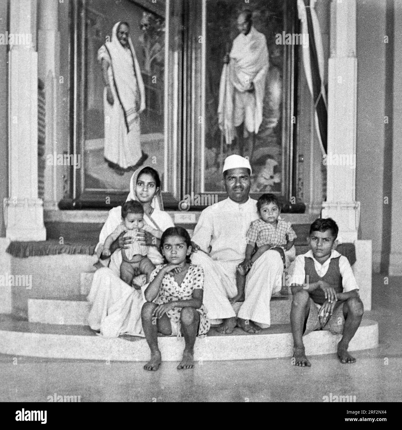 Vecchia foto vintage in bianco e nero degli anni '1900 di famiglia indiana marito moglie figli sotto Kasturba Mahatma Gandhi ritratto Rajkot Gujarat India anni '1950 Foto Stock