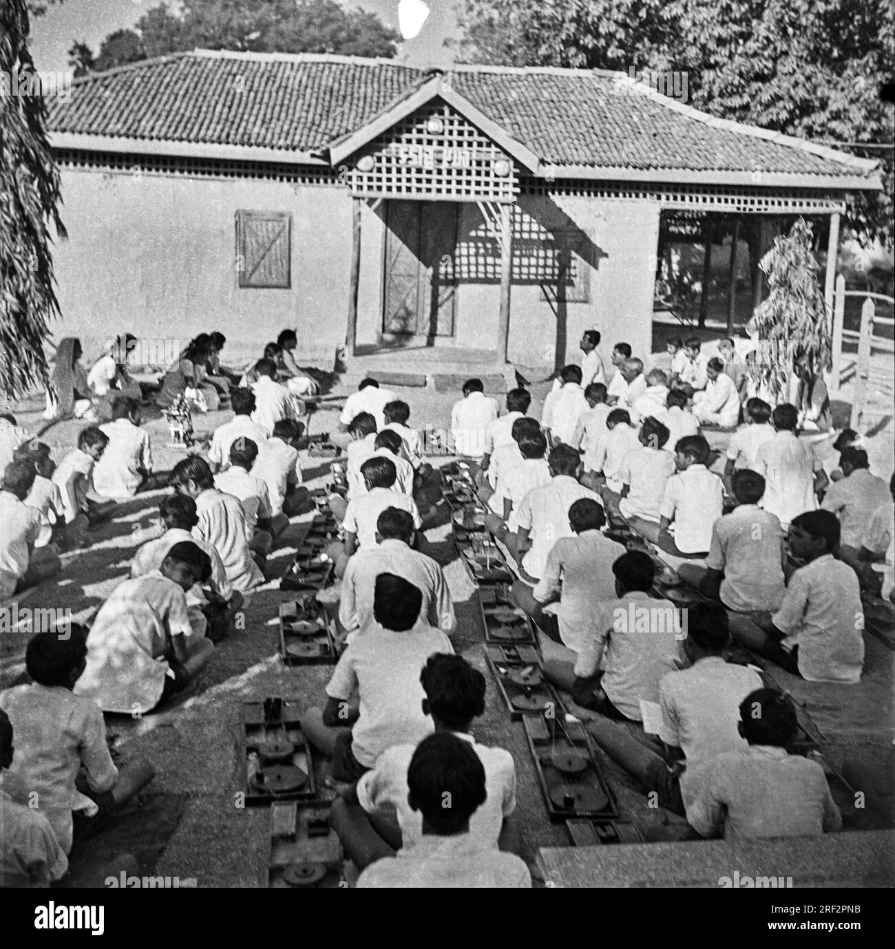 Vecchia immagine in bianco e nero anni '1900 di bambini delle scuole che imparano a girare i filati usano l'India 1940s Foto Stock