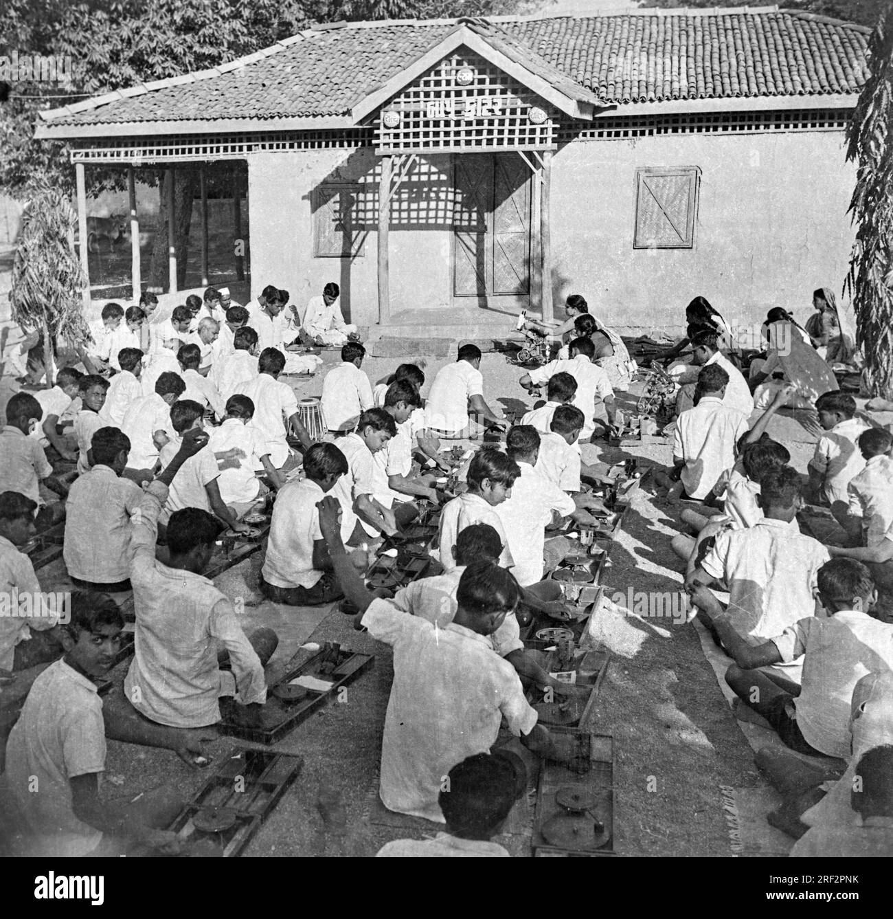 Vecchia immagine vintage in bianco e nero degli anni '1900 dei bambini delle scuole indiane che imparano a girare i filati usano l'India 1940s Foto Stock