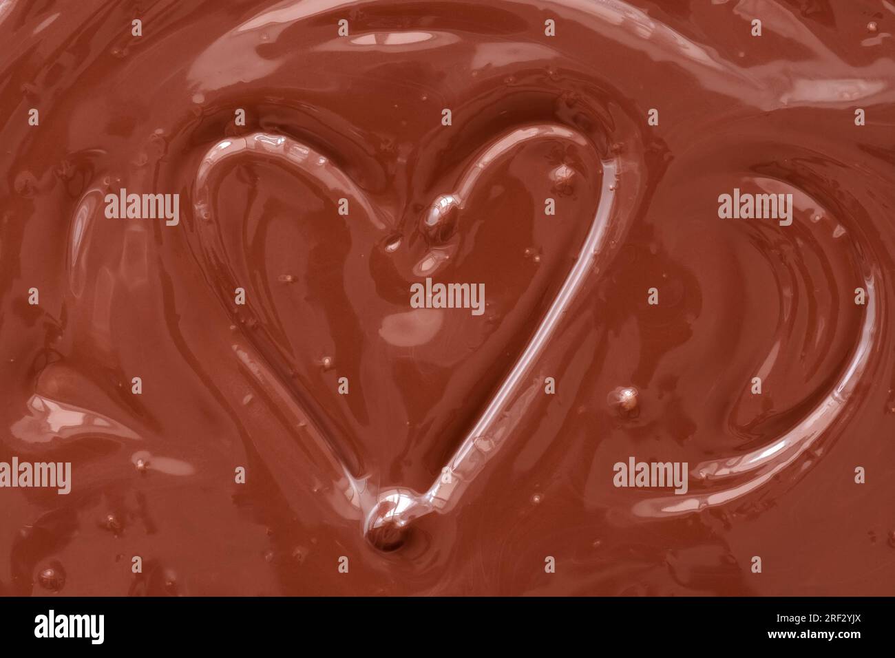 Consistenza di cioccolato liquido con un cuore. San Valentino. Foto Stock