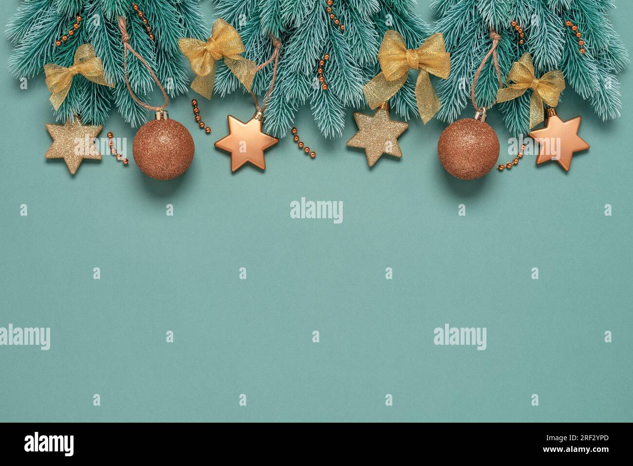 Splendido confine di Natale o Capodanno con decorazioni dorate, sfondo color pastello. Vista dall'alto, base piatta, spazio di copia. Foto Stock