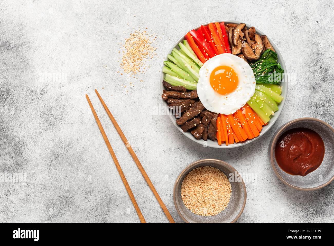 Korean Bibimbap. Cucina tradizionale coreana. Vista dall'alto, base piatta. Sfondo grunge chiaro Foto Stock