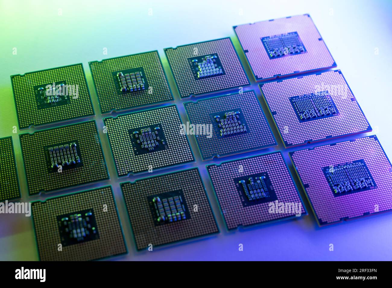 Raccolta di processori per computer (CPU) illuminati in verde e blu su una superficie luminosa Foto Stock