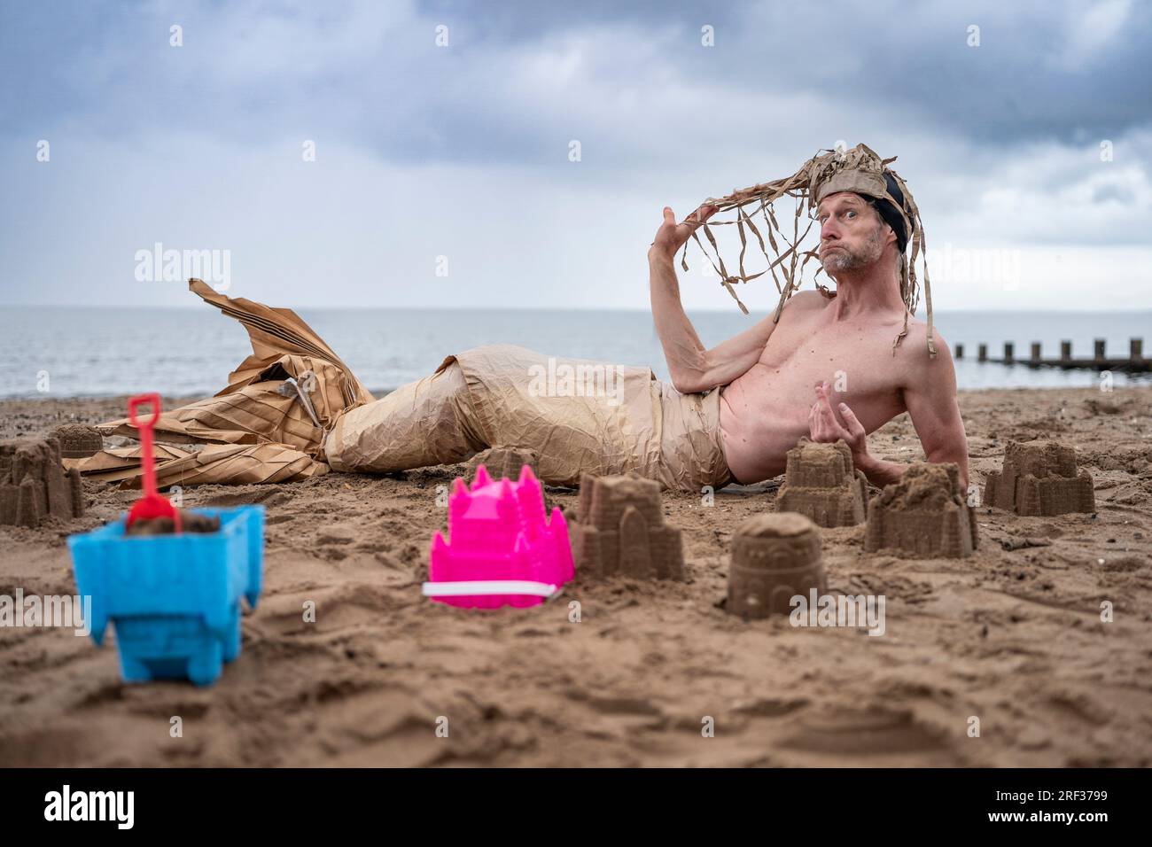 Edimburgo, Scozia, Regno Unito. 31 luglio 2023. Una sirena si rilassa sulla spiaggia di Portobello per promuovere il premiato Moliere The Ice Hole: Una produzione commedia di cartone. Questo nuovo spettacolo del gruppo compagnie le Fils du Grand Réseau, (qualcosa per il Weekend). Lo spettacolo è raccontato utilizzando mille pezzi di cartone mentre il duo racconta un viaggio epico dai fiordi dell'Islanda alla polvere del deserto spagnolo. Iain Masterton/Alamy Live News Foto Stock