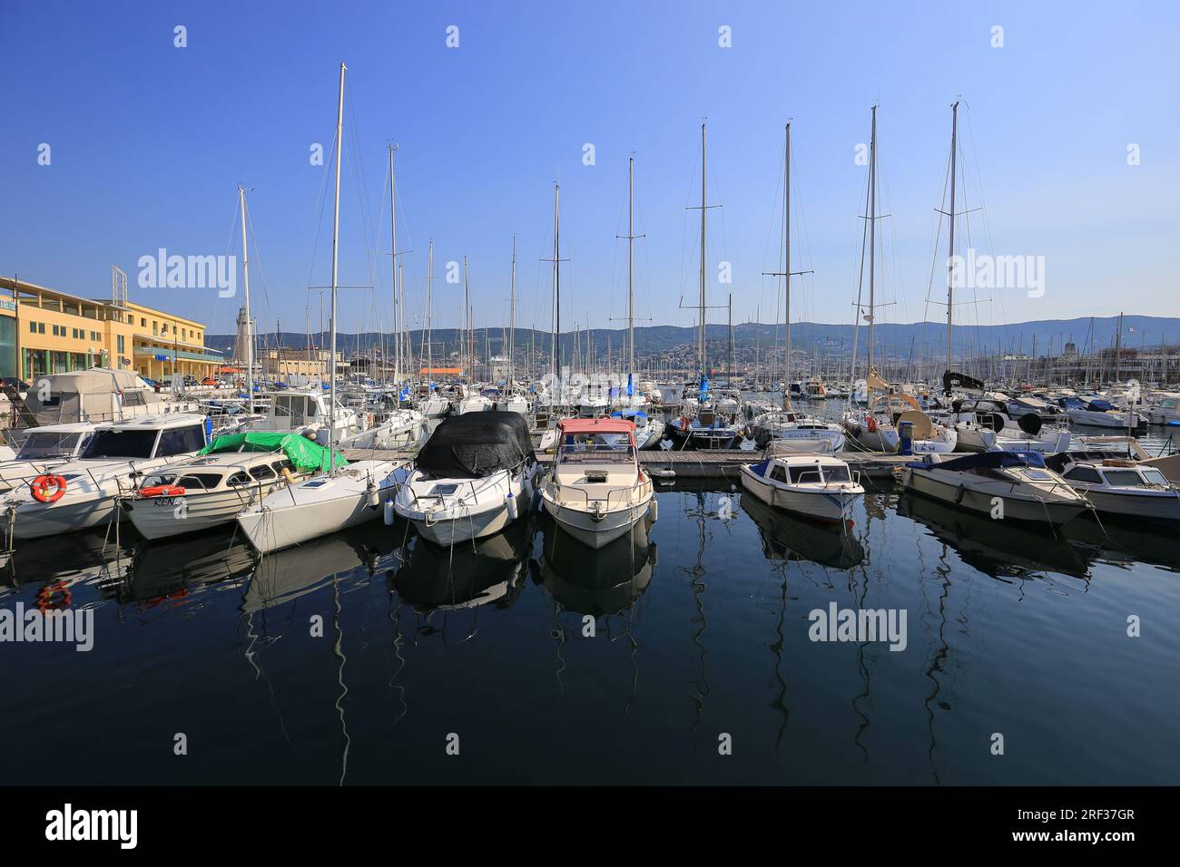 Barche a motore e a vela ormeggiate nel porticciolo di Trieste Foto Stock