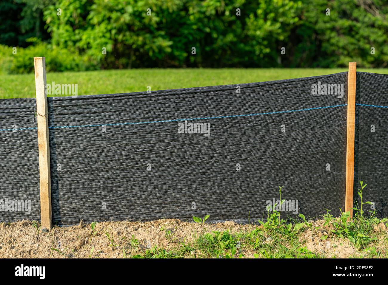 Tessuto Silt Fence con pali in legno installati prima dell'inizio della costruzione. Foto Stock