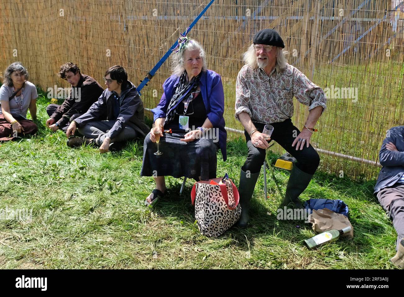 Persone sedute fuori da una tenda del festival ascoltando la musica ma non davanti agli altoparlanti. WOMAD 2023 Foto Stock