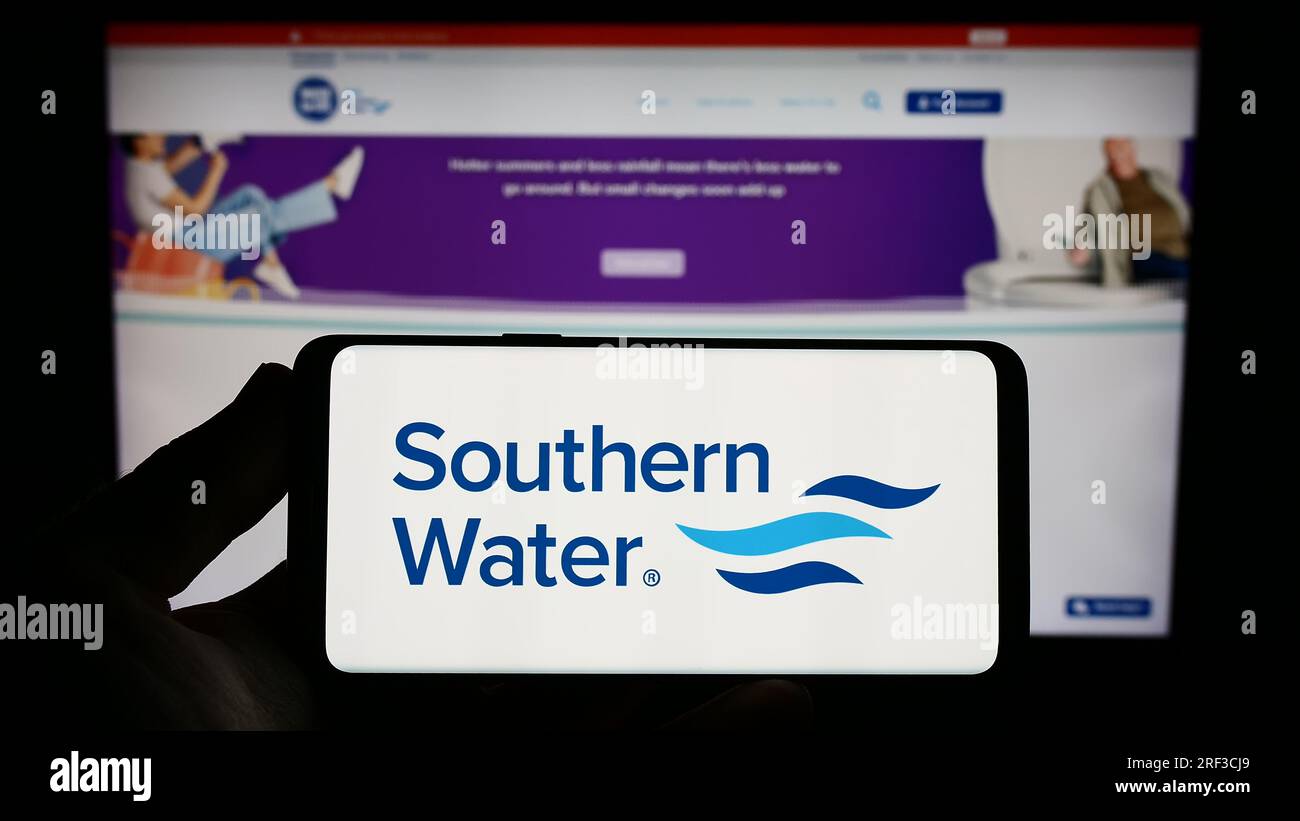 Persona che possiede uno smartphone con il logo della società britannica Southern Water Services Limited sullo schermo davanti al sito Web. Concentrarsi sul display del telefono. Foto Stock