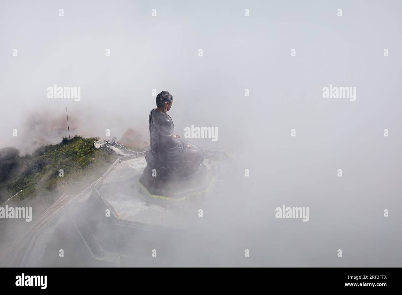 Statua di bronzo del Buddha in cima alla vetta del monte Fansipan, nella misteriosa nebbia. Provincia di Lao Cai, Vietnam Foto Stock