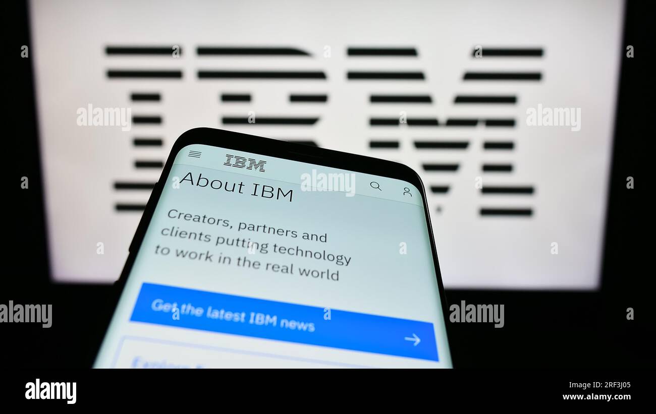 Telefono cellulare con pagina Web di International Business Machines Corporation (IBM) sullo schermo davanti al logo. Mettere a fuoco in alto a sinistra sul display del telefono. Foto Stock