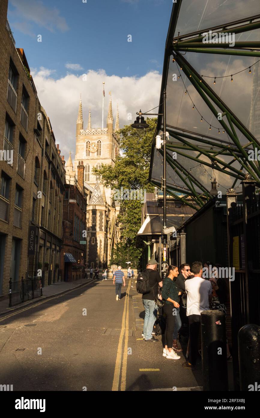 I Millennials socializzano in una graziosa strada laterale che conduce alla Cattedrale di Southwark a Southwark, Londra, Inghilterra, Regno Unito Foto Stock