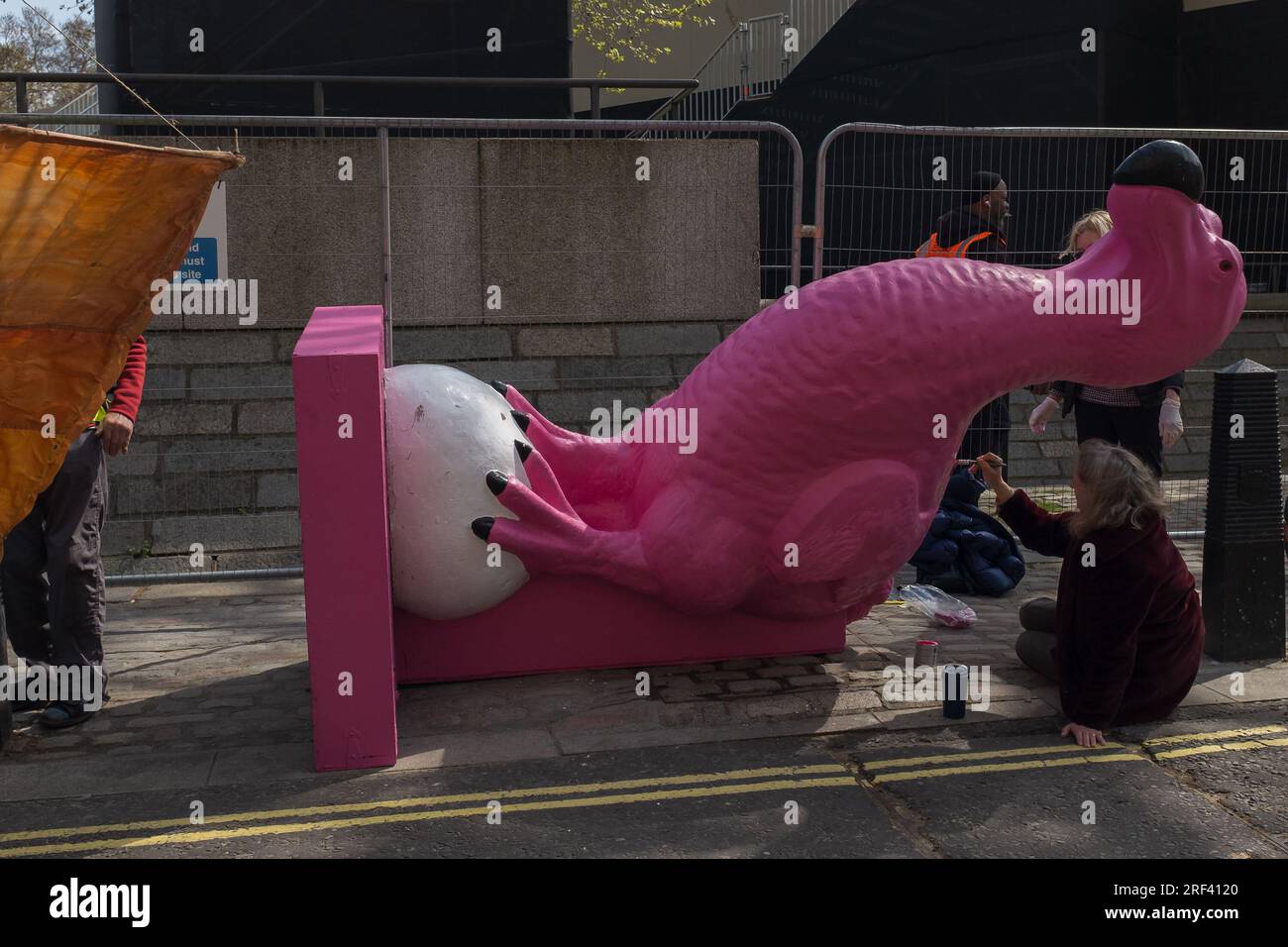 Londra, Regno Unito, 2023. Nella giornata della Terra, un attivista sta mettendo gli ultimi tocchi di vernice al dodo rosa di Extinction Rebellion che rappresenta le estinzioni degli animali Foto Stock