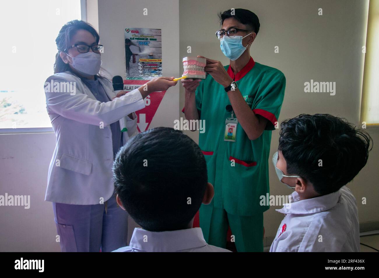 I dentisti forniscono istruzione su come mantenere l'igiene dentale e la salute agli studenti delle scuole elementari che visitano l'ospedale Vania Bogor, in Indonesia Foto Stock