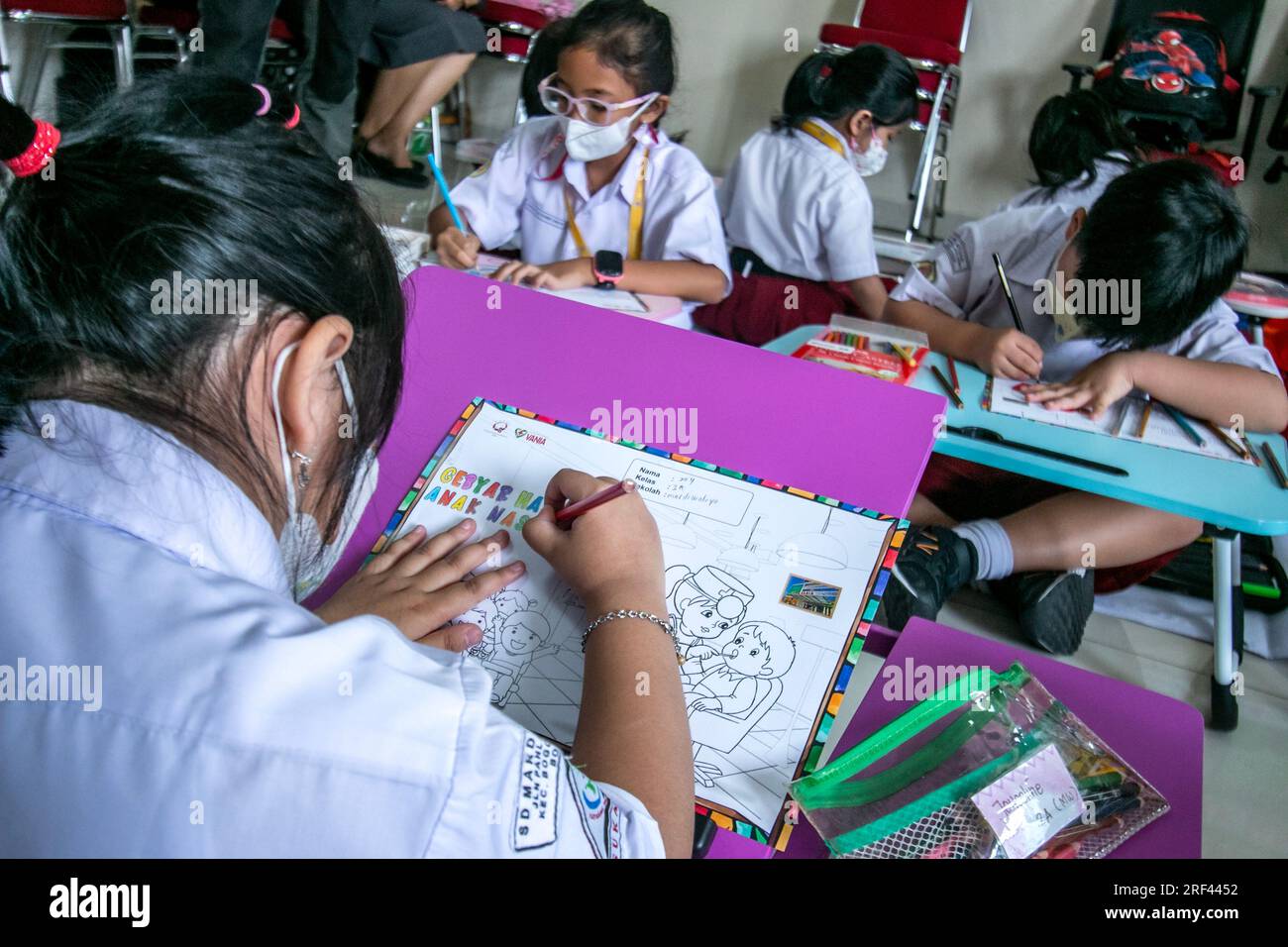 Gli studenti delle scuole elementari a Bogor City, Indonesia, svolgono attività di colorazione su immagini a tema sanitario mentre visitano l'ospedale Vania Bogor Foto Stock