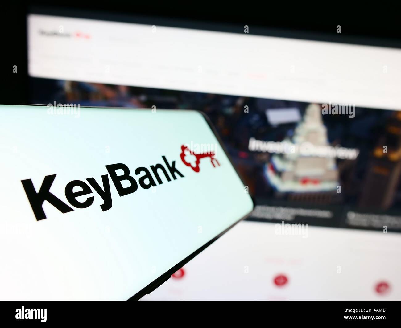 Telefono cellulare con logo della società finanziaria americana KeyCorp (KeyBank) sullo schermo davanti al sito Web. Mettere a fuoco il display centrale sinistro del telefono. Foto Stock