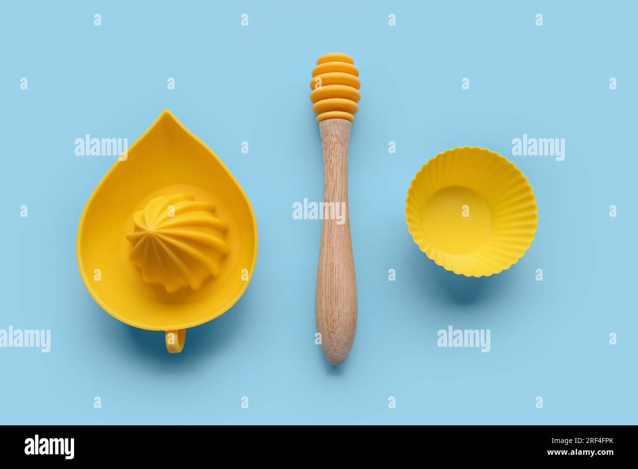 Spremiagrumi, cucchiaia al miele e tazza per muffin su sfondo colorato Foto Stock