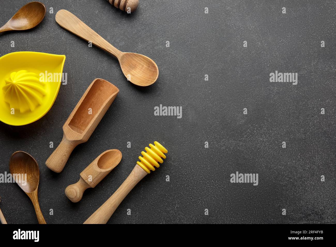 Set di diversi utensili da cucina con spremiagrumi su sfondo scuro Foto Stock