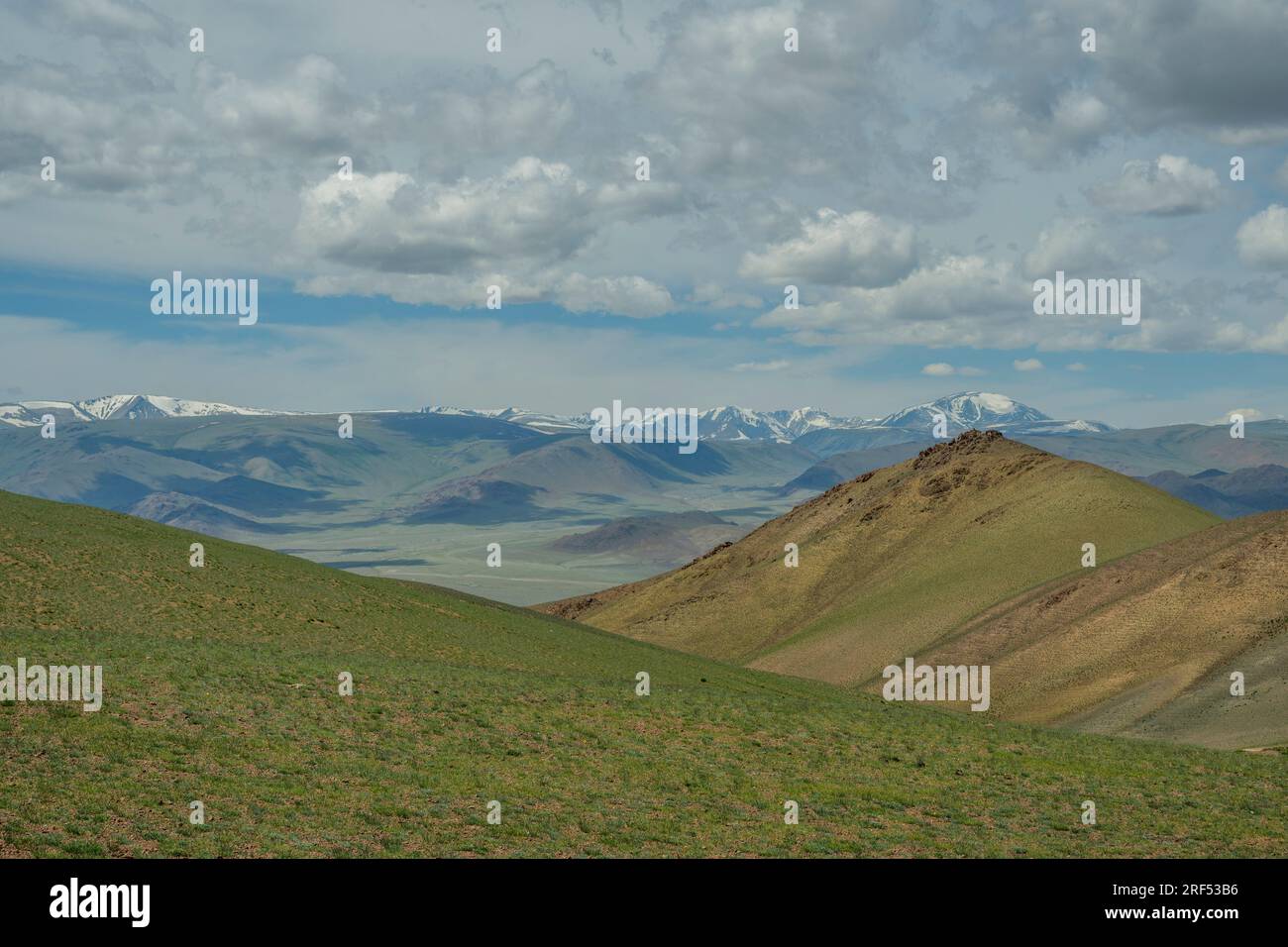 Ammira da un passo di montagna il paesaggio roccioso e asciutto con le montagne innevate dell'Altai (montagne Altay) vicino a Ulgii nella provincia di Bayan-Ulgii in WE Foto Stock