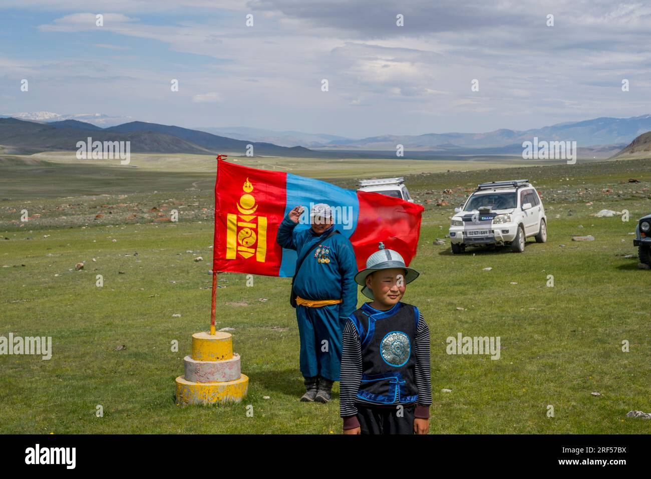Un uomo e un ragazzo in posa davanti alla bandiera nazionale mongola presso il luogo di un festival locale di Naadam nella valle del fiume Sagsai, una valle remota nella Foto Stock