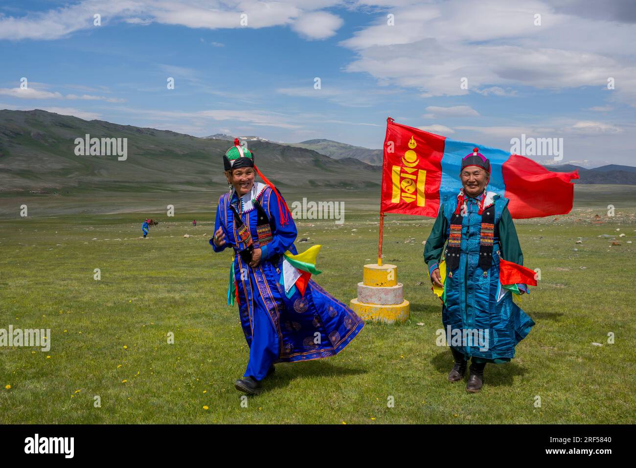 Due donne in posa di fronte alla bandiera nazionale mongola presso il luogo di un festival locale di Naadam nella valle del fiume Sagsai, una valle remota nell'alt Foto Stock