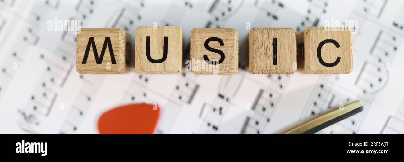 Cubi di legno con lettere musicali e chitarra raccolta di note musicali. Foto Stock