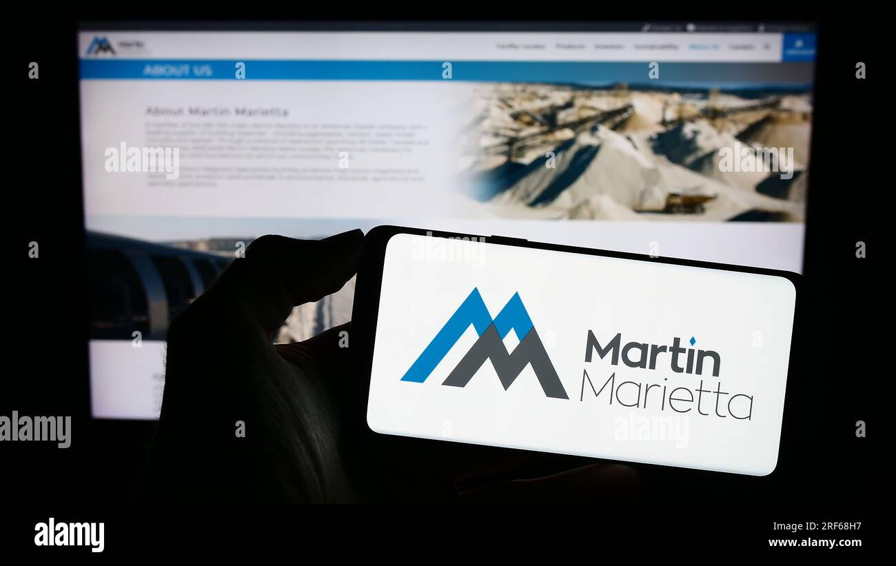 Persona che possiede uno smartphone con il logo dell'azienda statunitense Martin Marietta Materials Inc. Sullo schermo davanti al sito Web. Concentrarsi sul display del telefono. Foto Stock