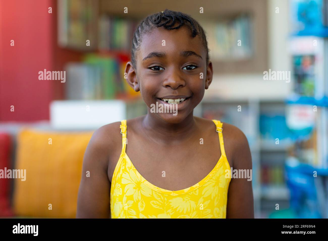 Ritratto di una studentessa afroamericana felice che indossa un vestito giallo in classe Foto Stock