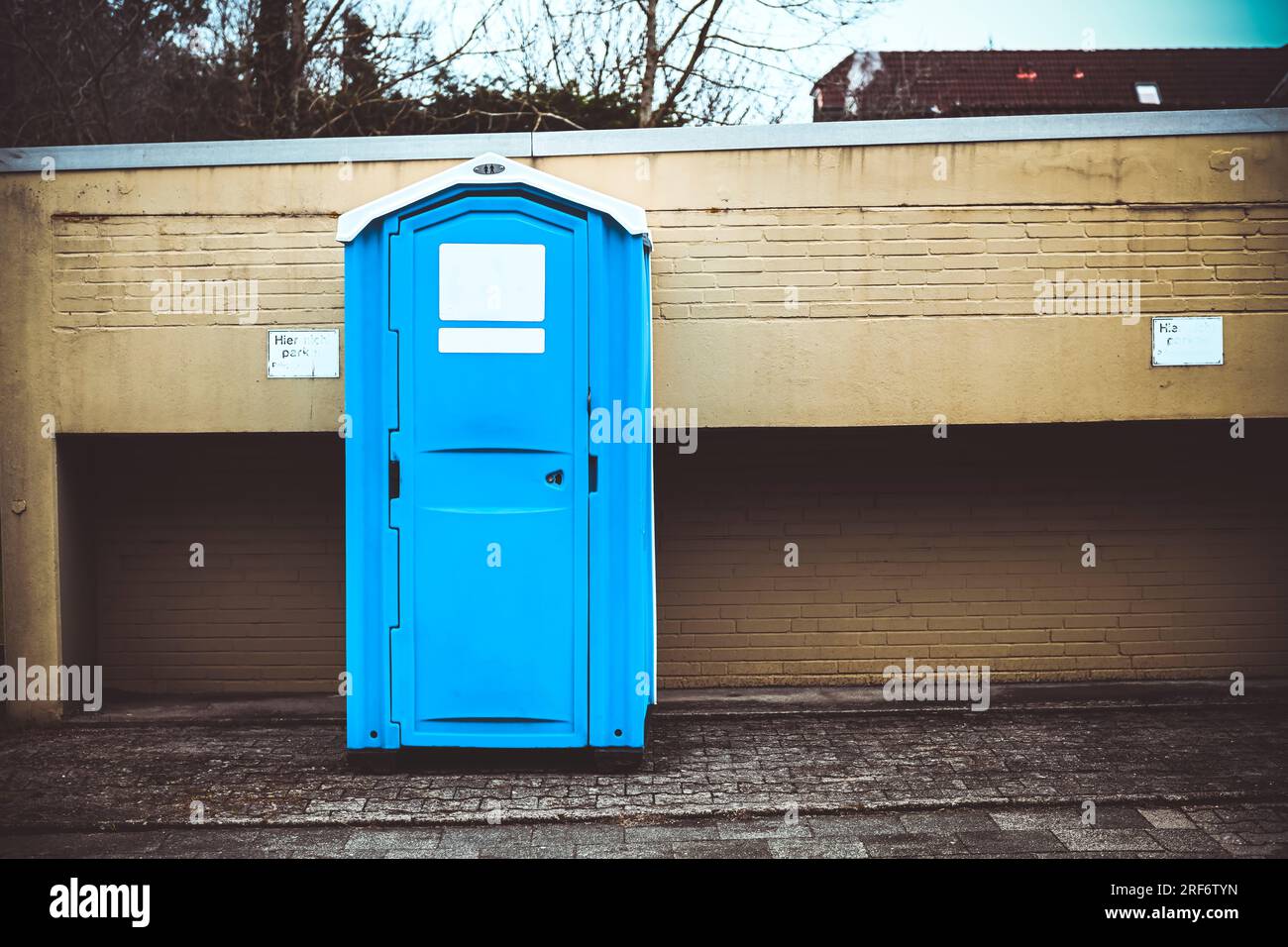 Mobile Toilettenkabine vor einer Mauer Foto Stock