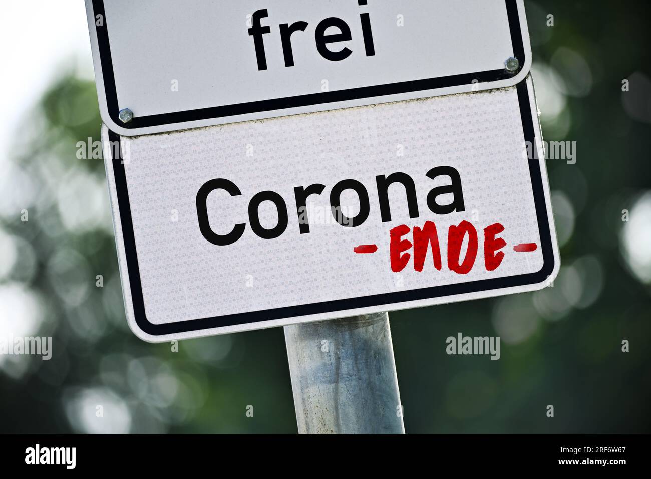 FotoMONTAGE, Schild mit Aufschrift Corona und Ende-Schriftzug, Symbolfoso Ende der Corona-Pandemie Foto Stock