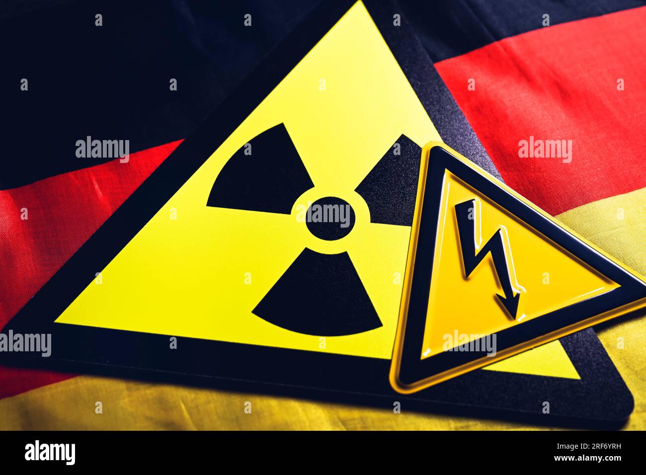 Schild mit Radioaktivitätssymbol und Schild mit Strompfeil auf Deutschlandfahne, Symbolfoto für AKW-Abschaltung und Energieversorgung Foto Stock