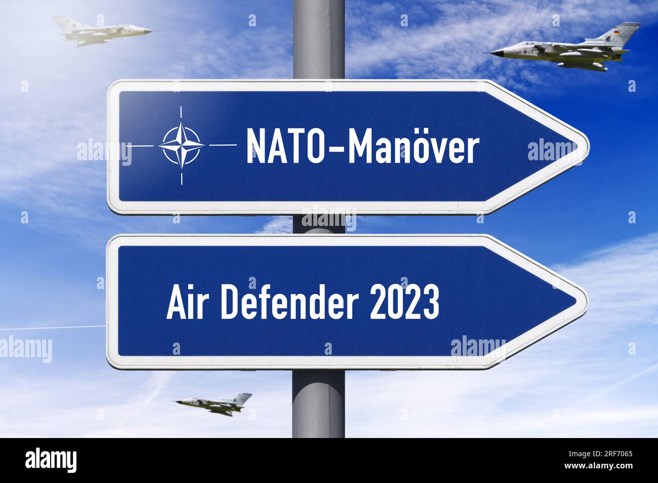 FOTOMONTAGE, Wegweiser mit Aufschrift NATO-Übung und Air Defender 2023, NATO-Luftmanöver Foto Stock