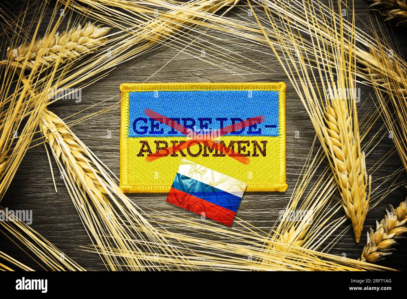 FOTOMONTAGE, Die Fahne der Ukraine mit durchgestrichener Aufschrift Getreideabkommen und russische Fahne Foto Stock