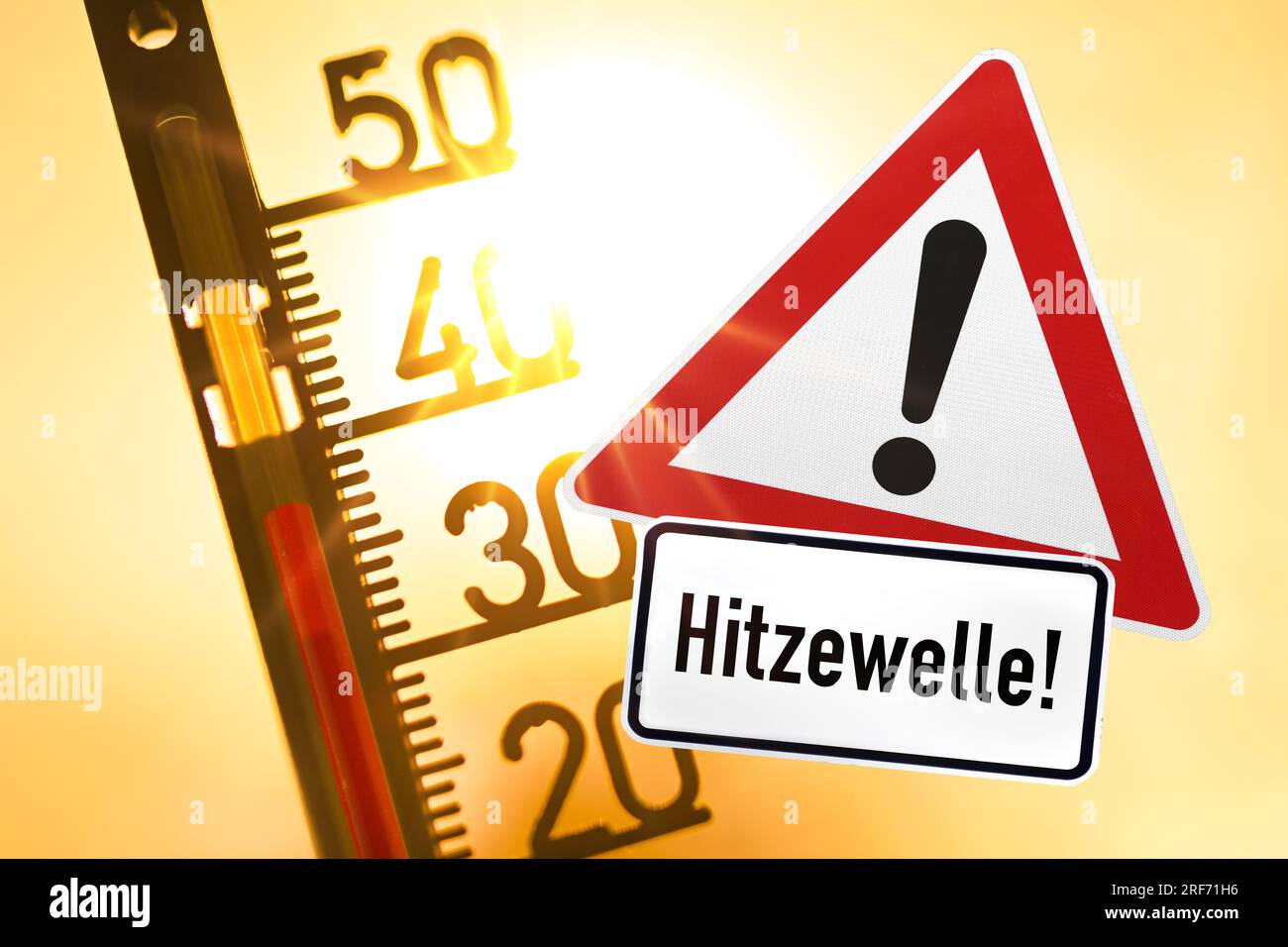 FOTOMONTAGE, Thermometer vor der Sonne und Warnschild mit Aufschriftz Hitzewelle Foto Stock