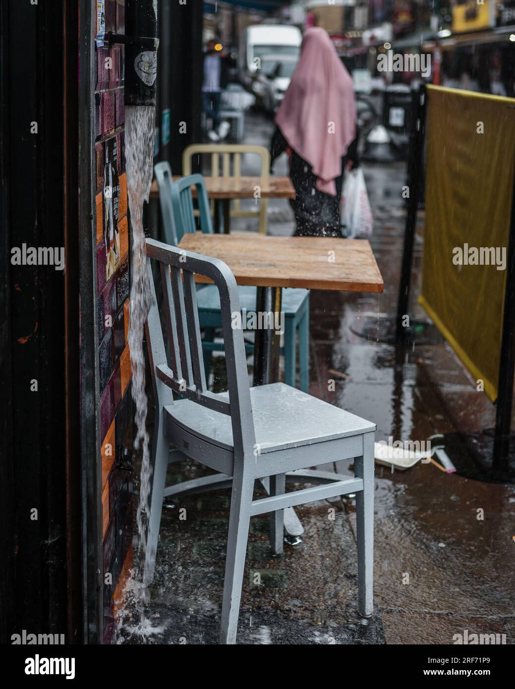 Tavoli all'aperto abbandonati mentre la pioggia scende a Londra. Foto Stock