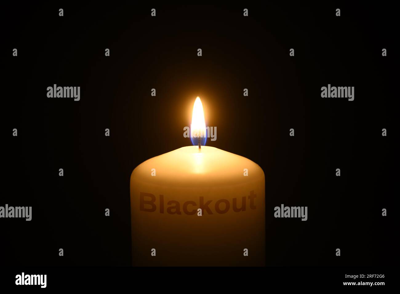 FOTOMONTAGE, Brennende Kerze mit Schriftzug Blackout Foto Stock