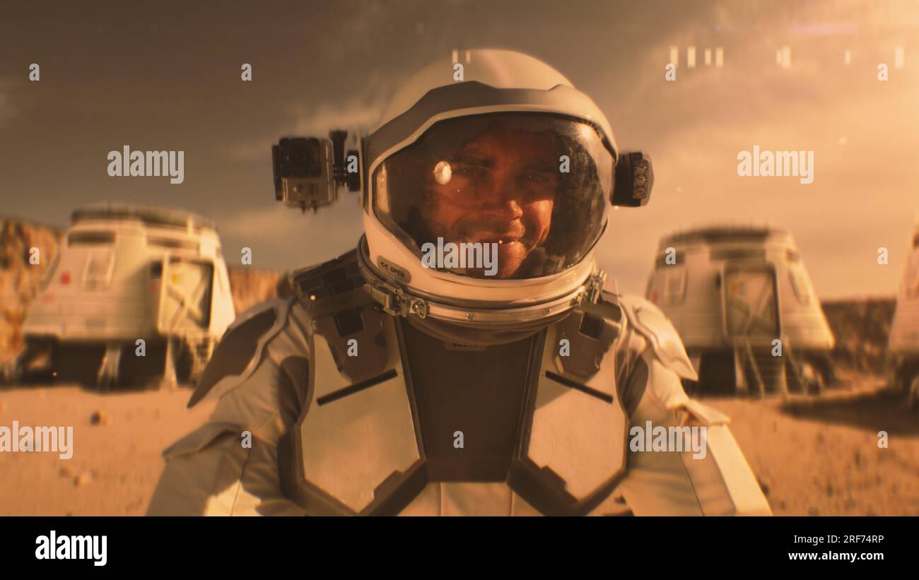 L'astronauta in tuta spaziale sorride, guarda la macchina fotografica. Nella stazione di ricerca o base scientifica su Marte. Esplorando la missione spaziale sul pianeta rosso. Concetto futuristico di colonizzazione ed esplorazione. Foto Stock